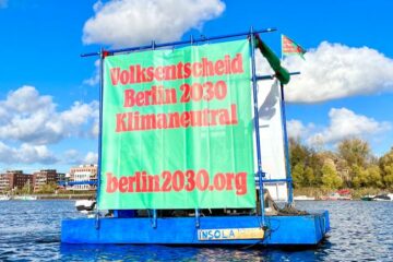 Transparent auf einem Floss im Wasser: „Volksentscheid Berlin 2030 Klimaneutral“