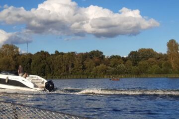 Motorboot rast zwischen Segelboot und Ruderboot durch mit ordentlichem Wellenschlag