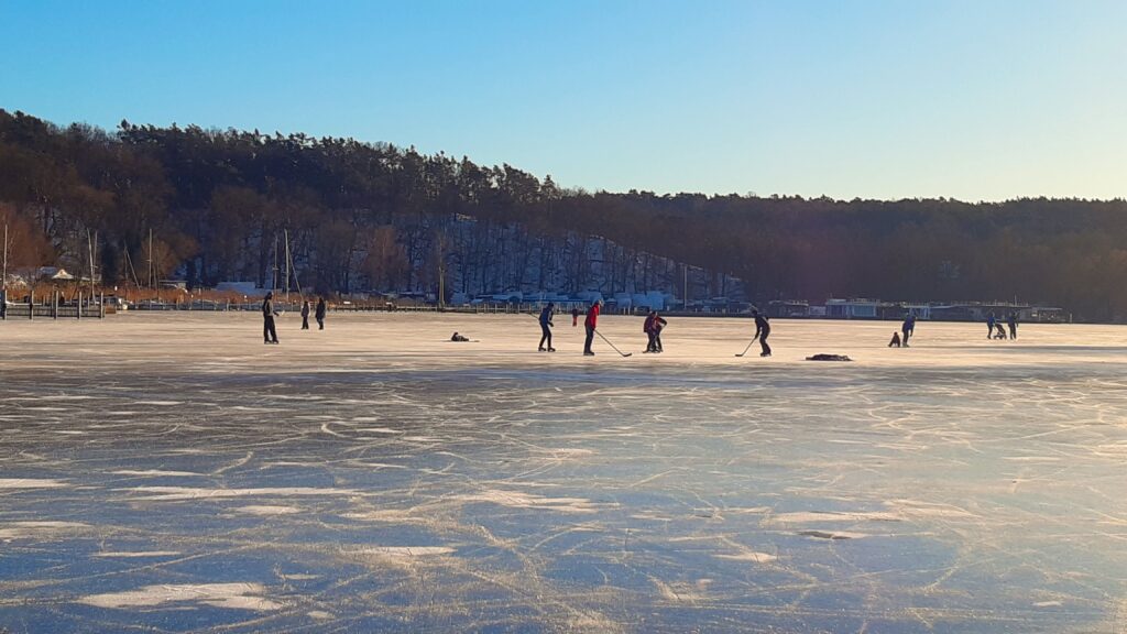 Zugefrorener Stößensee mit Eishocky-Spielern